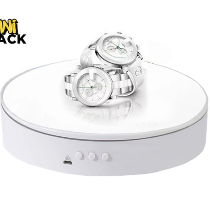 A pair of white watches displayed on a white motorized rotating stand against a plain background, with the "Kiwi Shack" logo in the top left corner.