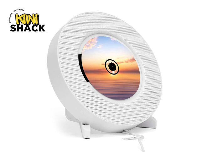 Round white device with a screen displaying a sunset, branded 'Kiwi Shack'.