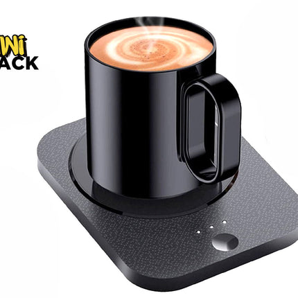 A black electric mug warmer base with a textured surface and power button, holding a black mug filled with steaming coffee, featuring a "Kiwi Shack" logo in the top left corner.