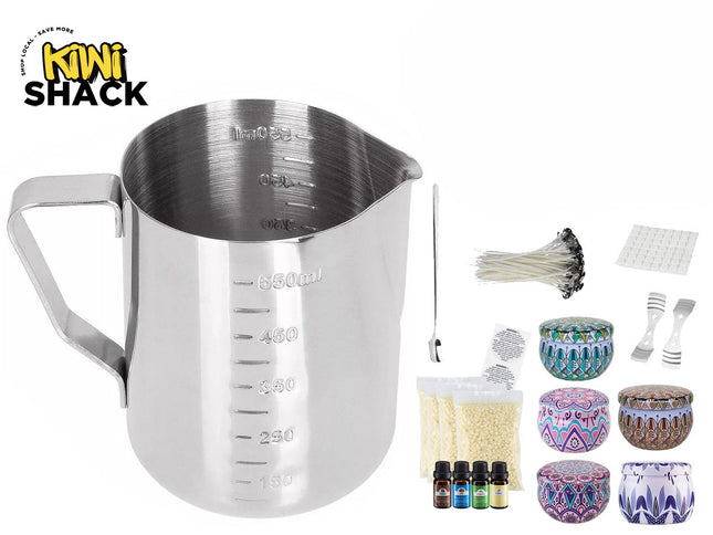 Stainless steel candle-making pouring pitcher / measuring jug with embossed volume markings, side handle, accompanied by candle wicks, wick centering tools, wick sticker pads, wax flakes/pellets, fragrance oil bottles, and decorative patterned tin containers with lids, plus the Kiwi Shack logo watermark.