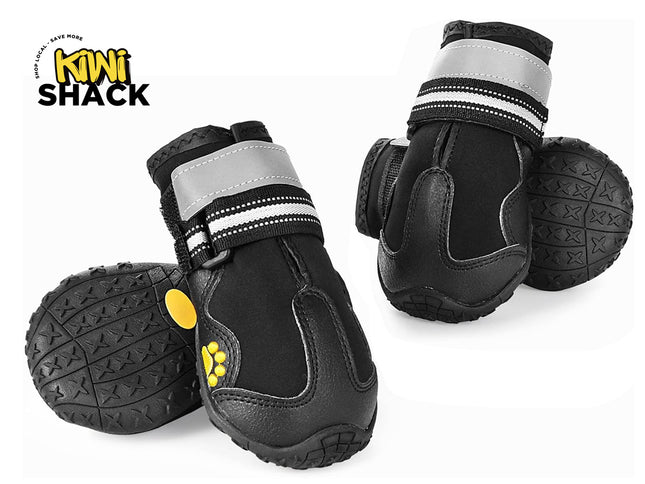 Set of black protective dog boots showing bottom lug soles, rubber toe caps, dual reflective and striped Velcro straps, yellow paw details, and Kiwi Shack logo watermark.