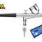 Chrome-plated double-action gravity feed airbrush featuring a black grip handle, top gravity fluid cup with lid, trigger control, air inlet fitting, separate knurled hose adapter nozzle, a blue-lined presentation storage box showing the kit contents, and the Kiwi Shack logo watermark.