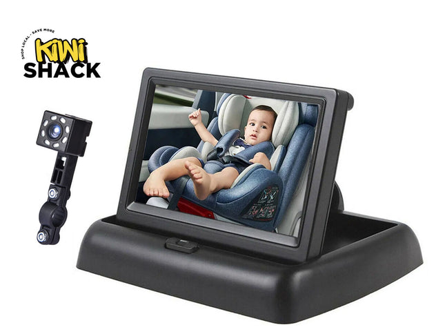 Black car rear-view mirror with an adjustable camera mount and a screen showing a baby in a car seat, on a white background with the Kiwi Shack logo.