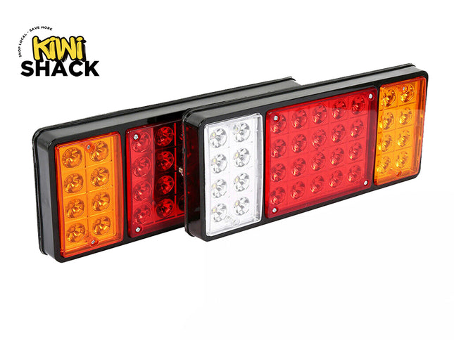 Pair of rectangular LED truck and trailer tail lights with black housings, featuring amber, red, and white/clear optical lens sections, branded with the "Kiwi Shack" logo in the top-left corner.