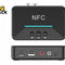 A black NFC Bluetooth audio receiver shown from the top and back perspectives against a white background, featuring playback buttons, a glowing status line, DC 5V power port, USB port, RCA audio out jacks, and an AUX out port, with the "Kiwi Shack" logo in the upper left corner.