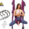 A woman sits cross-legged in a purple aerial yoga hammock with black straps and two silver carabiners on a white background, with the Kiwi Shack logo in the top left corner.