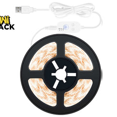 A coiled warm white LED strip light on a black spool with a white USB cable and controller, shown on a white background with the Kiwi Shack logo in the top-left corner.