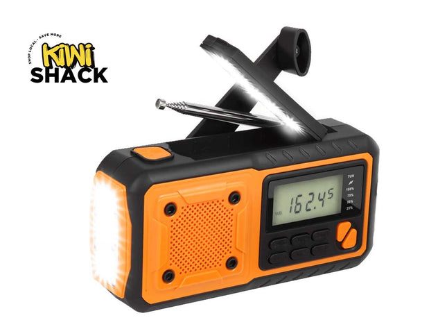 An orange and black Kiwi Shack portable emergency radio with built-in lights and a folding antenna, shown on a white background with the Kiwi Shack logo in the top-left corner.