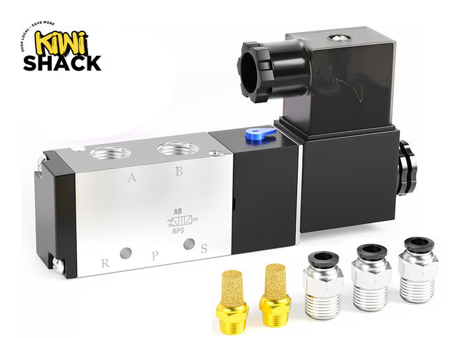 Pneumatic 5/2-way solenoid valve with aluminum/black body labeled A, B, R, P, S and AB/RPS schematic, featuring an electrical coil housing with transparent cover, manual override switch, Kiwi Shack logo watermark, two brass pneumatic silencers/exhaust mufflers, and three push-to-connect fitting connectors