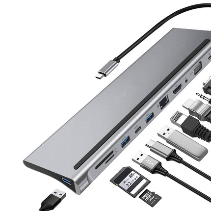 A silver aluminum multi-port hub with attached and surrounding cables, including a USB-C cable, HDMI-style cable, USB-A and USB-C adapters, an SD card, and an SD card reader, on a white background.