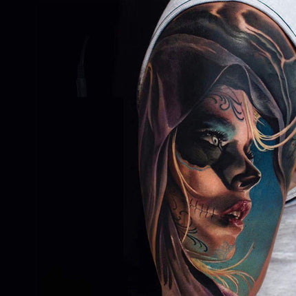 Tattoo of a woman's face on a person's arm with a dark background