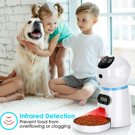 Children with a dog and a pet food dispenser on a carpeted floor.