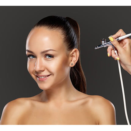 Woman receiving airbrush makeup application on a dark background