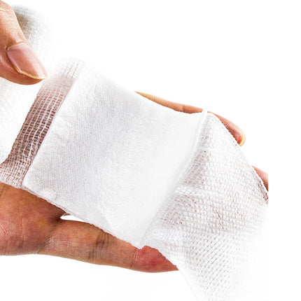 Close-up of a hand with a white bandage on a white background
