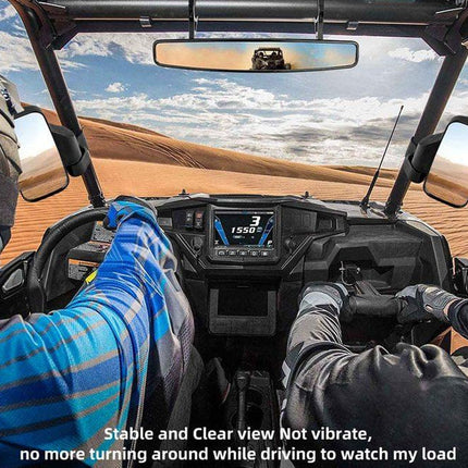 Interior of a vehicle with a driver and passenger, showing a scenic view through the windshield.