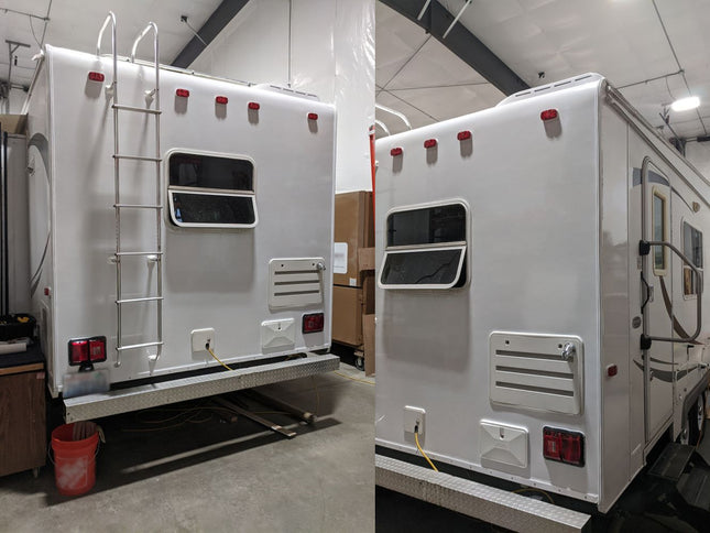 A white travel trailer or RV shown from the rear and side in a warehouse or showroom setting, with a metal ladder on the back, windows, vent grilles, and red taillights.
