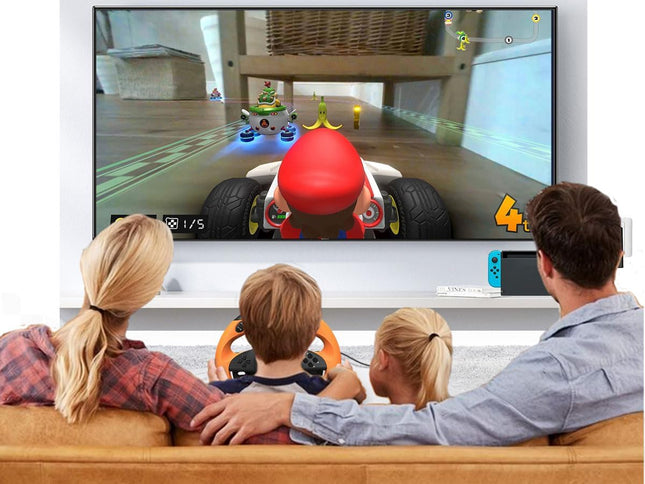 Family playing a racing video game on a Nintendo Switch console with a large screen displaying the game.