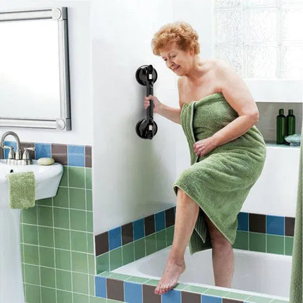 Woman wrapped in a green towel using a bathroom safety handle.