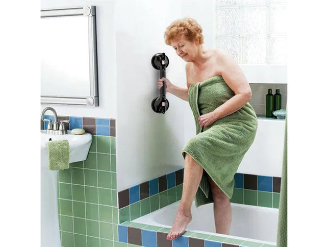 Woman wrapped in a green towel using a bathroom safety handle.