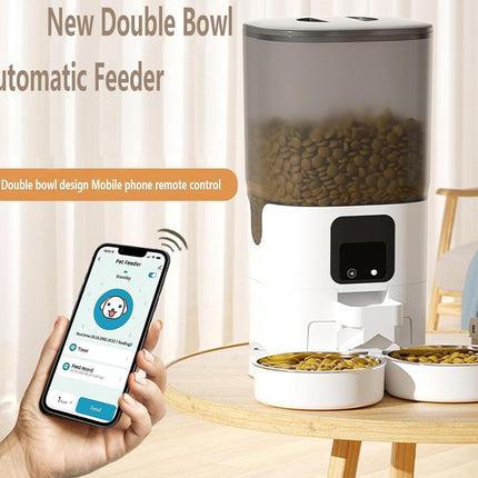 Automatic pet feeder with smartphone app control on a table.