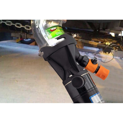 Close-up of a car jack with a green label on a vehicle, likely in a garage setting.