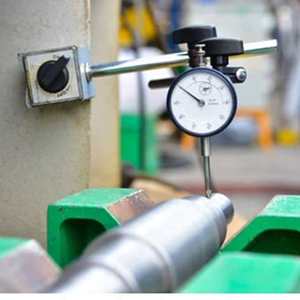 Mechanical measurement tool on a green surface with blurred background