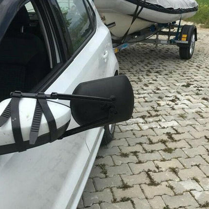 Car with a kayak attached to the side, on a paved road.