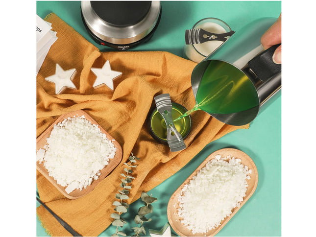 Person pouring a green liquid into a small container on a teal surface with star decorations.