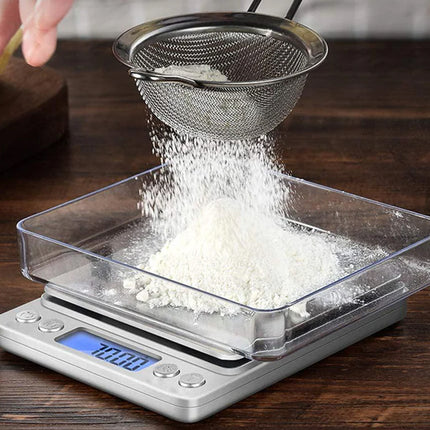 Sifting flour into a digital kitchen scale on a wooden surface