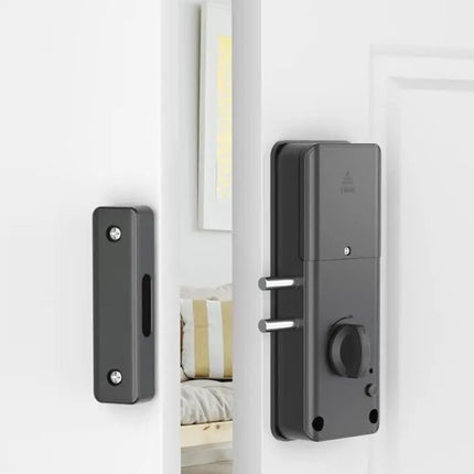 Smart door lock mounted on a white door with a mirror reflection.