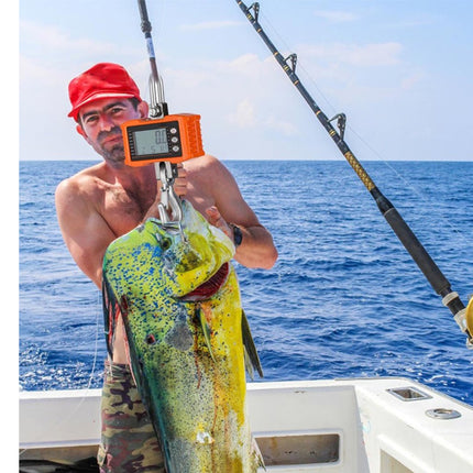 Man holding a large fish caught on a boat with ocean in the background