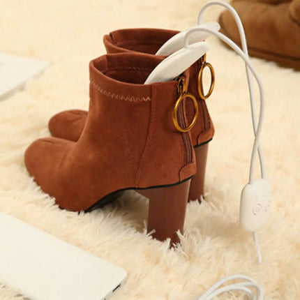 Brown suede boots with gold buckles on a beige surface