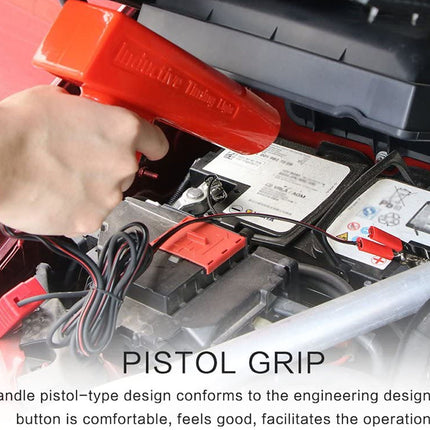 Person using a red battery jump starter with a pistol grip on a car battery.