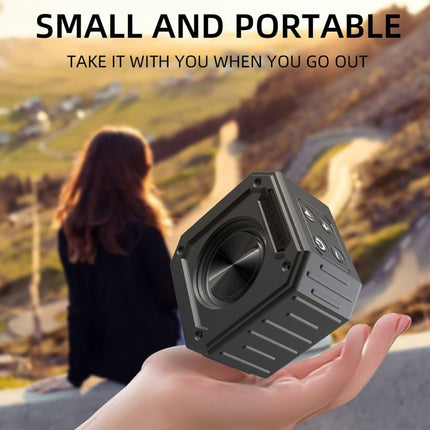 Hand holding a small black speaker with scenic background