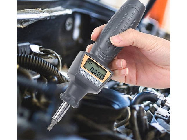 Digital dipstick being used to check oil level in a car engine