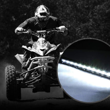 Person riding an ATV at night with a close-up of a light source.