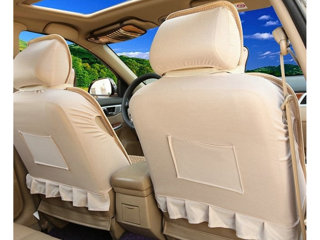 Beige car seat covers with ruffled trim and back pocket inserts installed on the front seats of a vehicle interior.