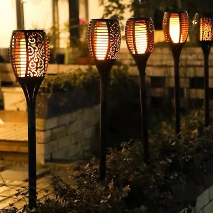 Solar-powered garden lights with decorative patterns on a garden path.