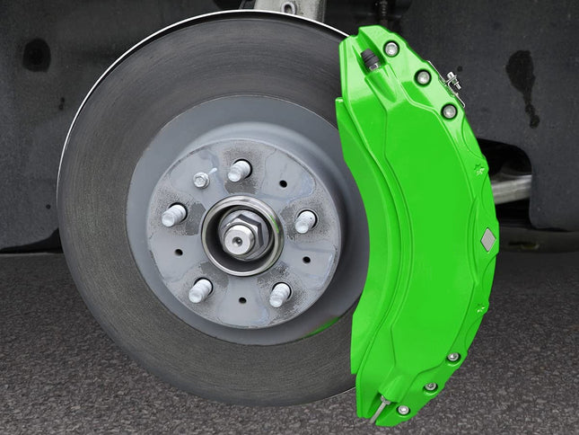 Close-up of a car wheel with a green brake caliper on a dark background