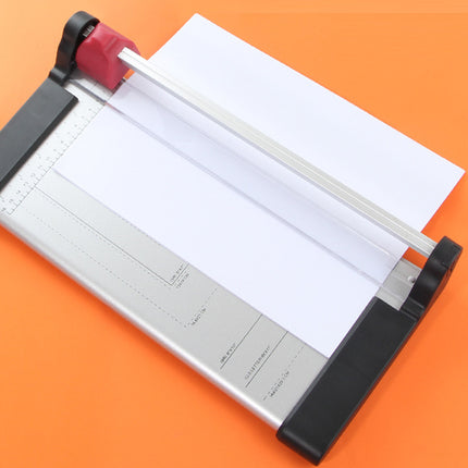 Paper trimmer with a sheet of paper on an orange background