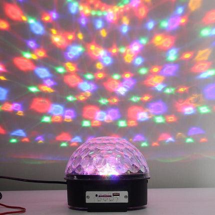 Colorful disco ball projector with multicolored light display on a wall.