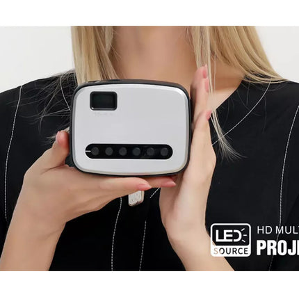 Person holding a LEX HD Multimedia Projector in front of their face on a white background