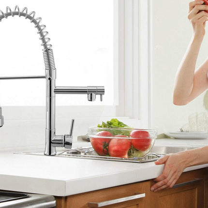 Person washing vegetables in a kitchen sink with a modern faucet.