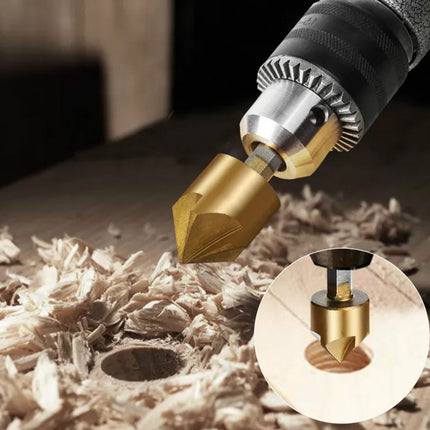 A close-up of a drill bit with a gold-colored cutting head mounted on a drill, shown drilling into wood with wood shavings around it. A circular inset shows a cross-section of the drill bit.