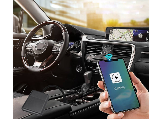 Car interior with smartphone displaying CarPlay on a screen, held by a hand.