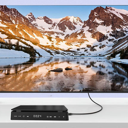 TV displaying a mountain landscape with a lake, connected to a media player on a white surface.