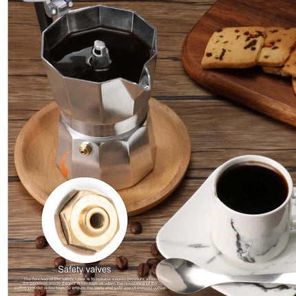 Stainless steel Moka pot on a wooden table with a cup of coffee and cookies.