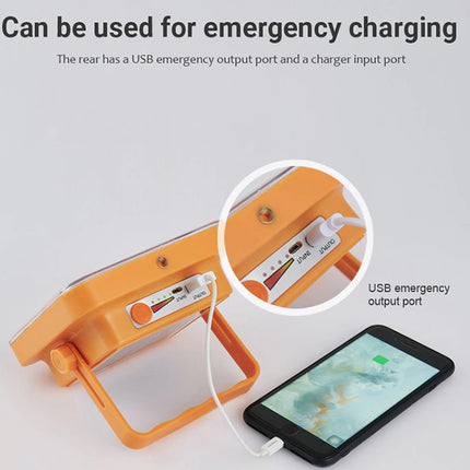 Orange emergency light with USB output port and smartphone charging, on a gray background.