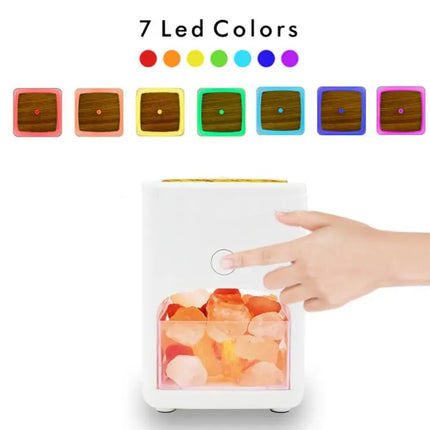A white LED salt lamp with a transparent front showing glowing orange salt crystals, with a hand pointing at the button. Above it, the text '7 Led Colors' and seven color swatches are shown on a white background.