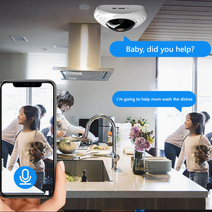 A smart home security scene showing a ceiling-mounted camera in a modern kitchen, with a hand holding a smartphone in the foreground displaying a live video call and text bubbles in the background.